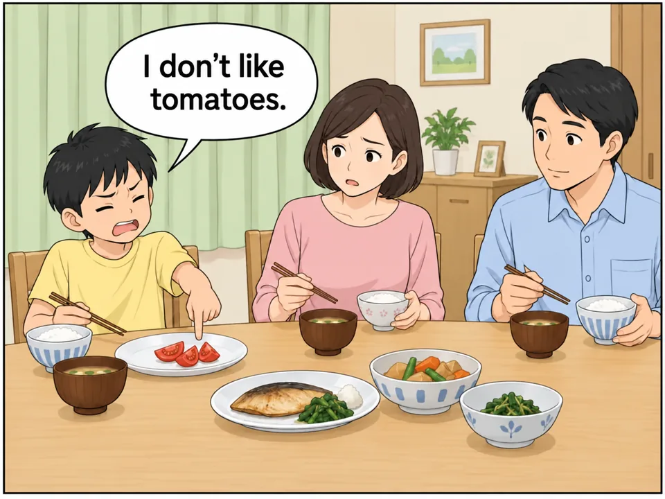 リクの家の食卓。リク(小学生)のサラダの皿にトマトだけが残っている。リクは顔をしかめてトマトを指さしている。母は困った顔。 吹き出し:I don't like tomatoes.